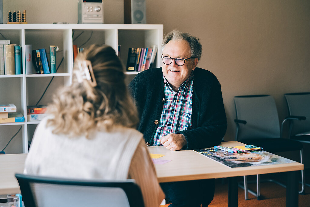 Psychotherapie Ein Psychologe redet mit einer Patientin.