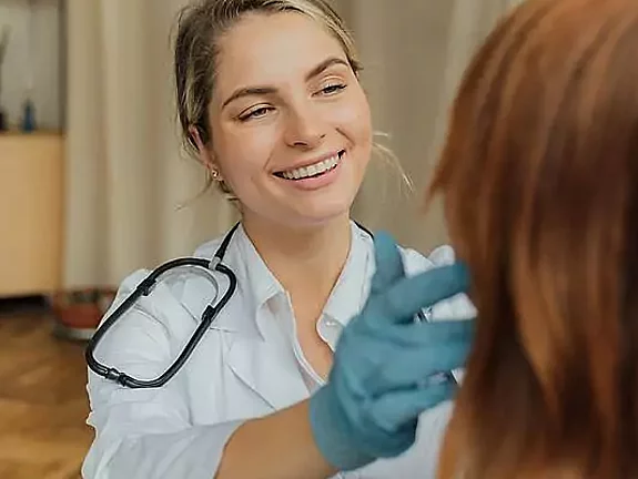 Ärztin Behandlung Eine freundliche Ärztin untersucht eine Patientin.