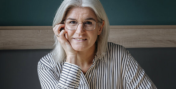 Nora Volmer-Berthele Nora Volmer-Berthele sitzt mit einem Spiel am Tisch.