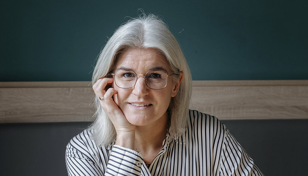 Nora Volmer-Berthele Nora Volmer-Berthele sitzt mit einem Spiel am Tisch.