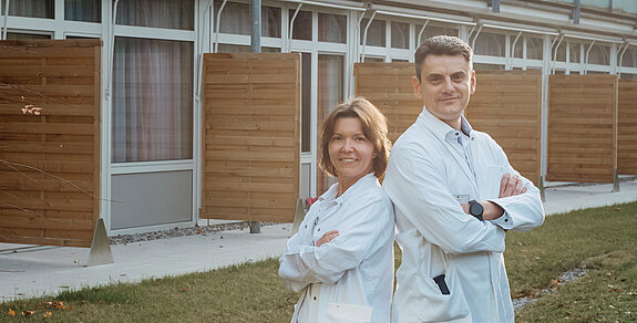 Ärzteehepaar Ein Ärzteehepaar steht vor der Rehaklinik.