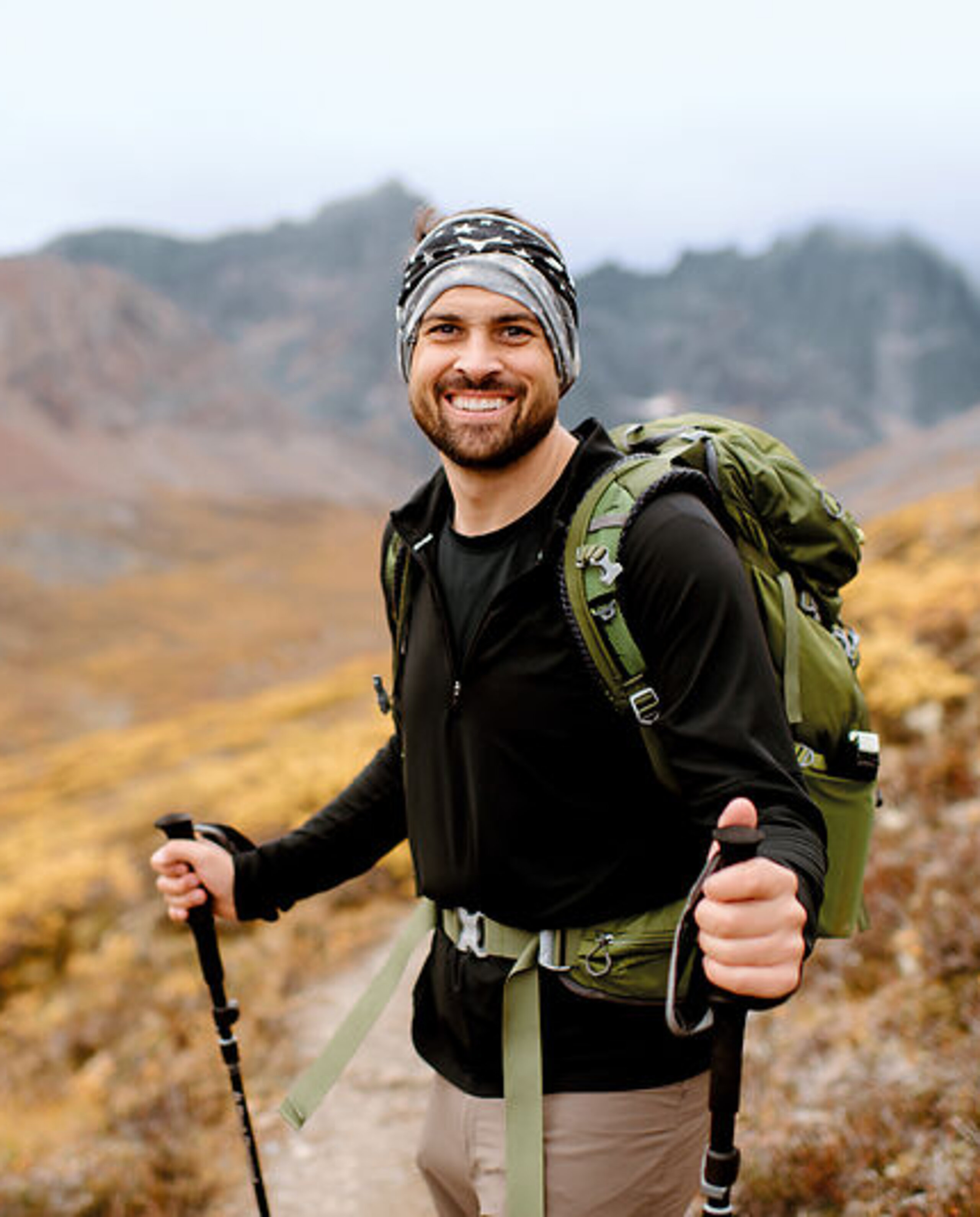 Wanderung Berge Ein junger Mann wandert mit Stöcken in den Bergen.