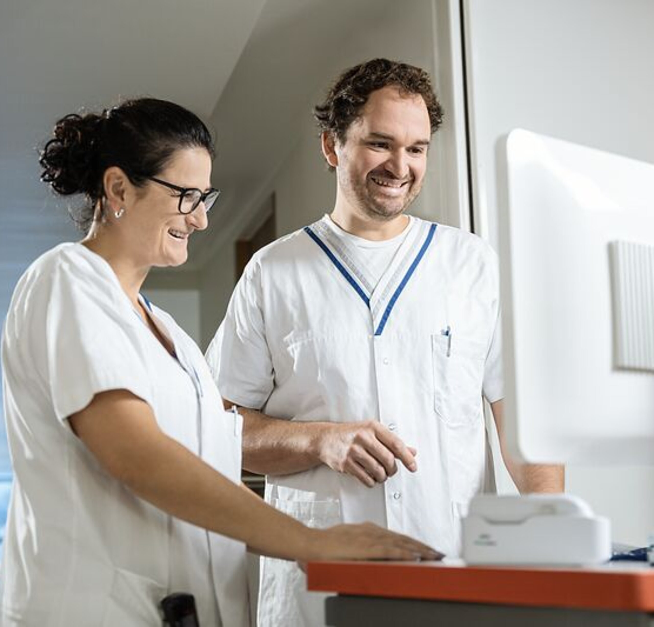 Pflegeteam am Bildschirm Zwei Pflegekräfte arbeiten gemeinsam an einem digitalen Visitenwagen.