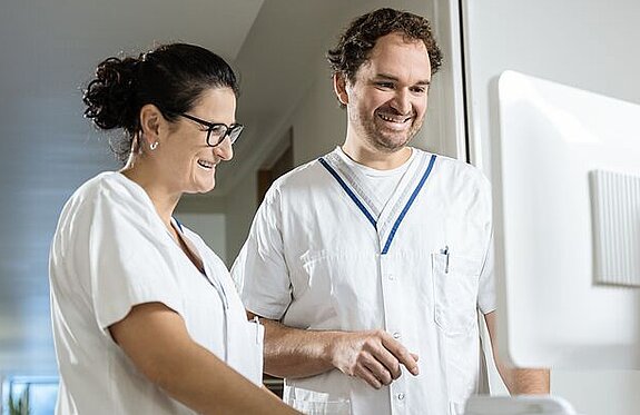 Pflegeteam am Bildschirm Zwei Pflegekräfte arbeiten gemeinsam an einem digitalen Visitenwagen.