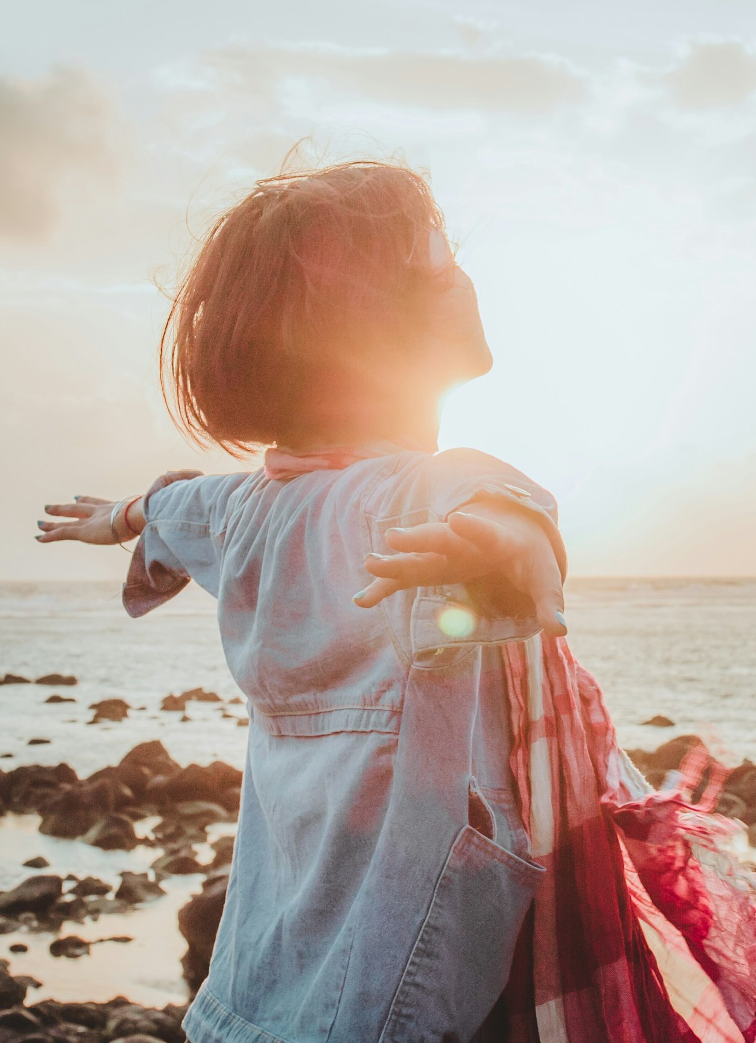 Einatmen Meer Eine Frau atmet tief ein mit ausgebreiteten Händen am Meer.