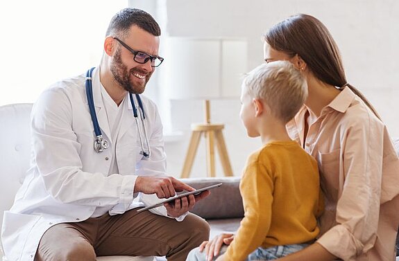 Arztgespräch Pädiatrie Ein Arzt redet mit einer Mutter mit Sohn.