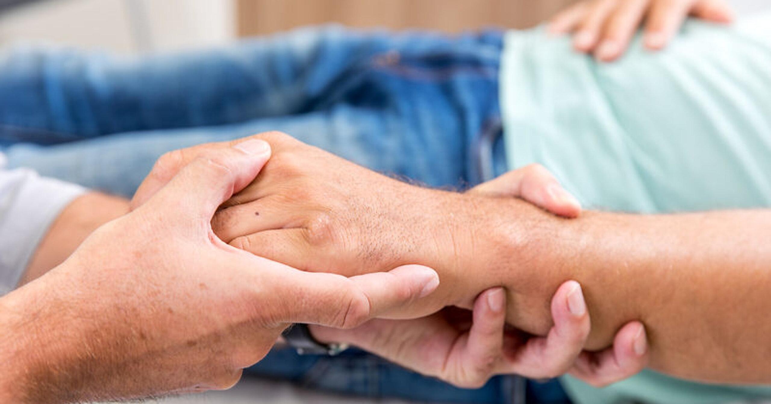 Hände Untersuchung Ein Arzt umfasst die Hand eines Patienten.
