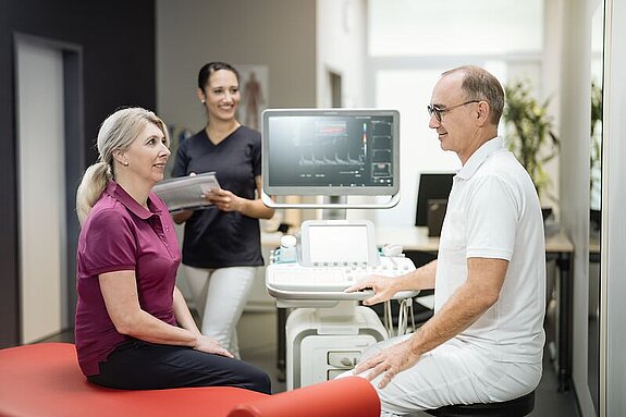 Professionalität Ein Arzt erklärt einer Patientin etwas.