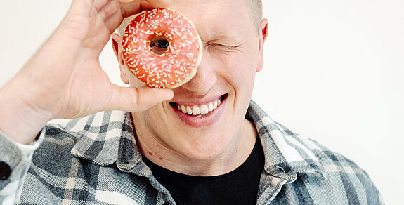 Jan Blaschko Jan Blaschko sieht mit einem Auge durch einen Donut.